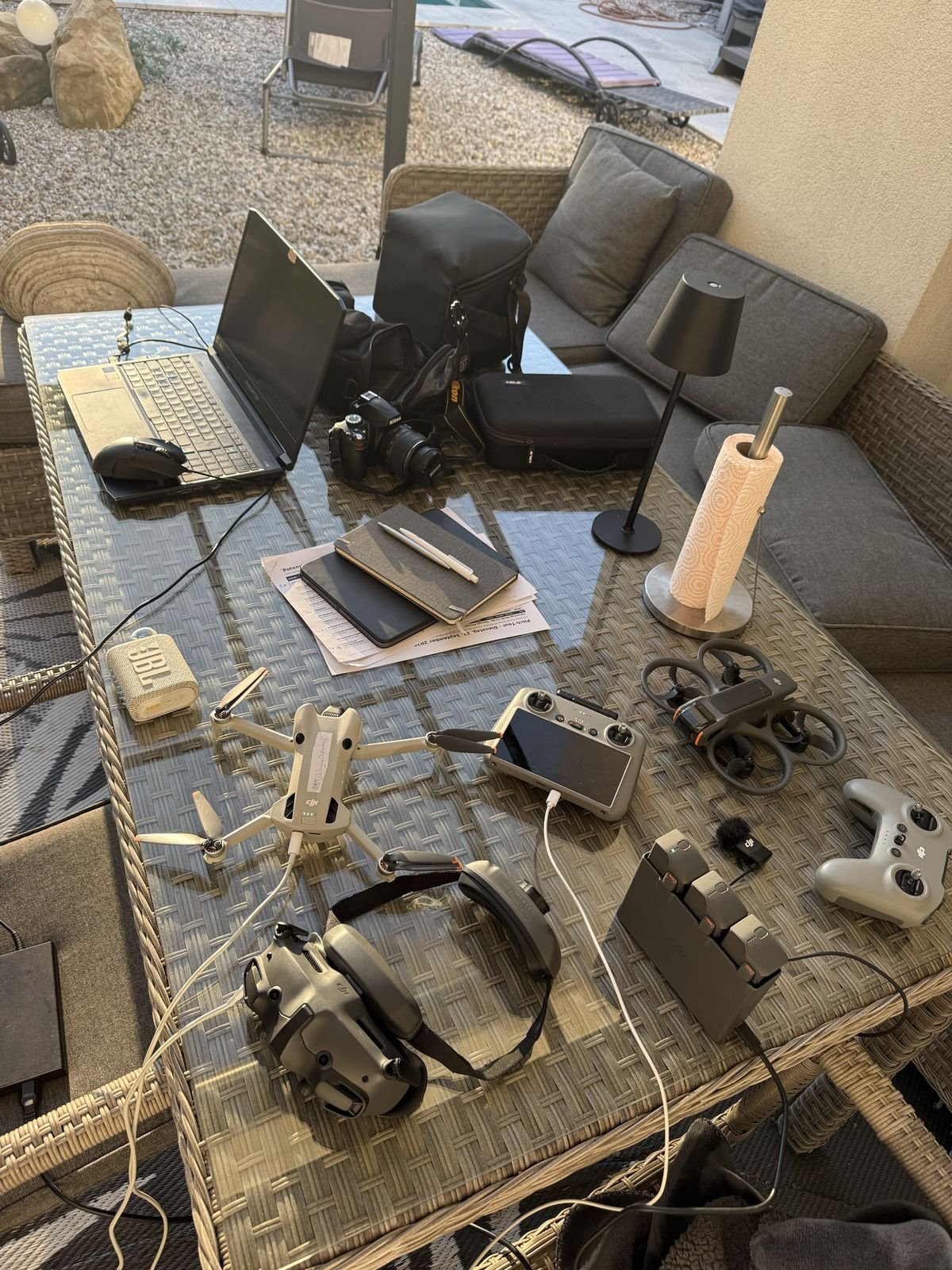 Drohnen, Kamera, Laptop und Akkus auf einem Tisch
