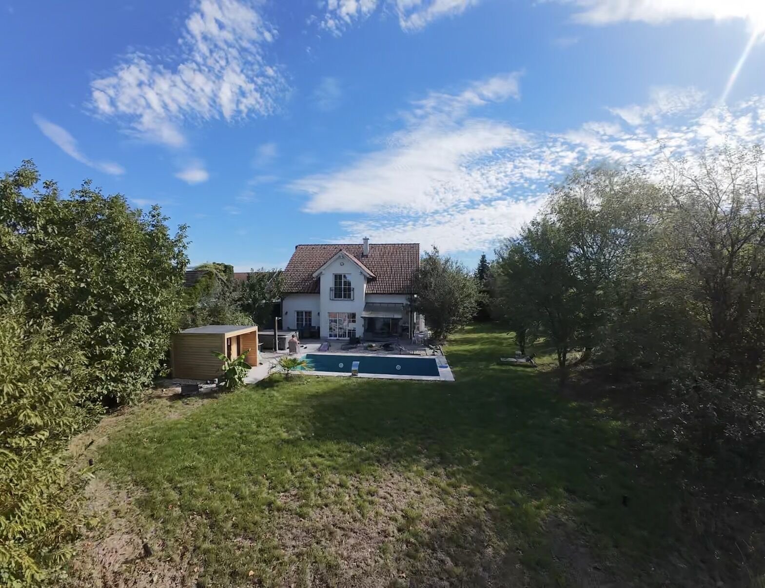 Garten mit Pool und Poolhaus, dahinter die weiße Villa in Eichgraben
