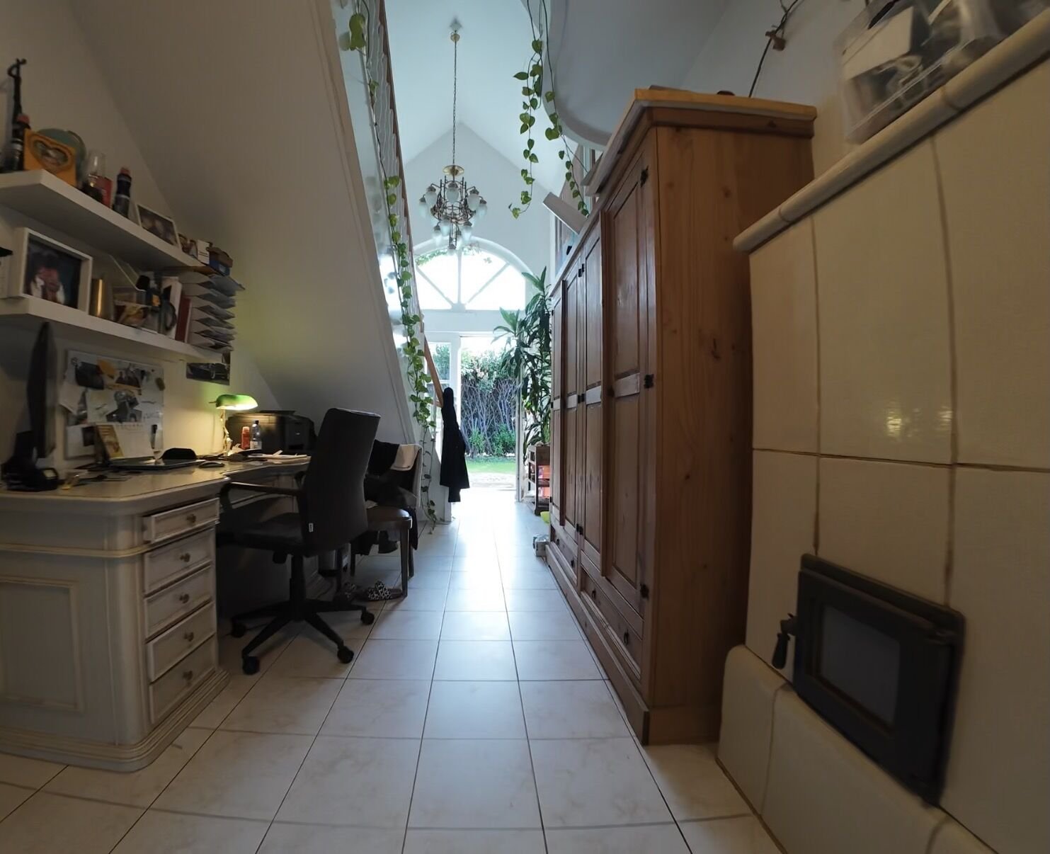 Langer Flur mit Schreibtisch unter der Treppe und Blick in den Garten
