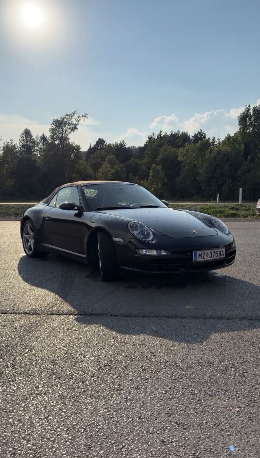 Schwarzes 911 Cabrio mit geschlossenem Verdeck in der Abendsonne